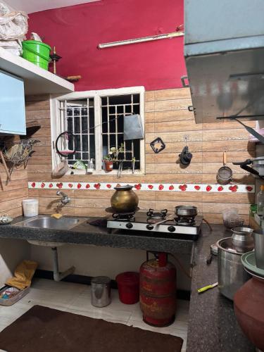 a kitchen with a sink and a stove at Aswin's Homestay 1bhk in Podanūr
