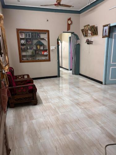 a living room with a tile floor and a mirror at Aswin's Homestay 1bhk in Podanūr