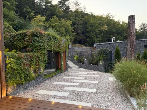 a walkway in a garden with a stone wall at Hrdlička Slapy Chalot in Buš