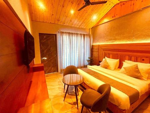 a hotel room with a bed and a television at The Edge Retreat A Premium Property in Mussoorie
