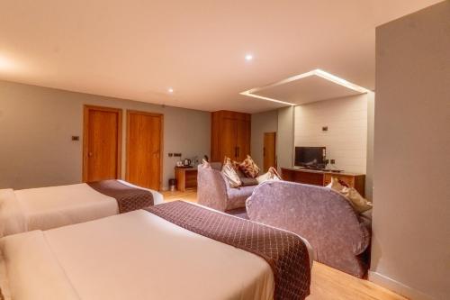 a hotel room with two beds and a couch at Kava Suites Namchi in Namchi