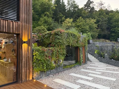 a garden with a stone wall and a building at Hrdlička Slapy Chalot in Buš