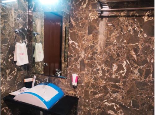a bathroom with a sink and a mirror at Hotel Orient Crown, Kolhapur in Kolhapur