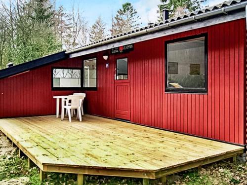 a red tiny house with a wooden deck at 5 person holiday home in Ry in Ry