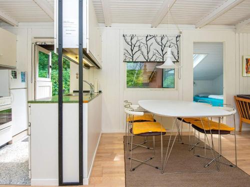 a kitchen with a white table and yellow chairs at 5 person holiday home in Ry in Ry