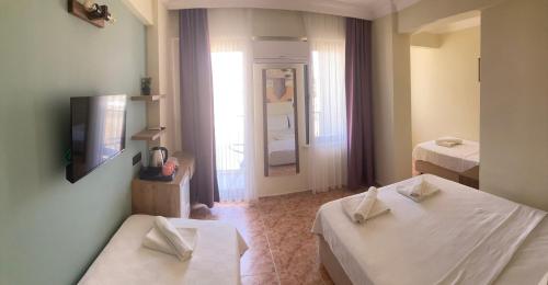 a hotel room with two beds and a window at Olimpia Hotel in Fethiye