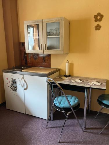 a kitchen with a table and a refrigerator and a table and chairs at Doppelzimmer vom Friesenhof Wieratal in Nobitz