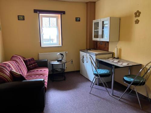 a kitchen with a couch and a table and a refrigerator at Doppelzimmer vom Friesenhof Wieratal in Nobitz