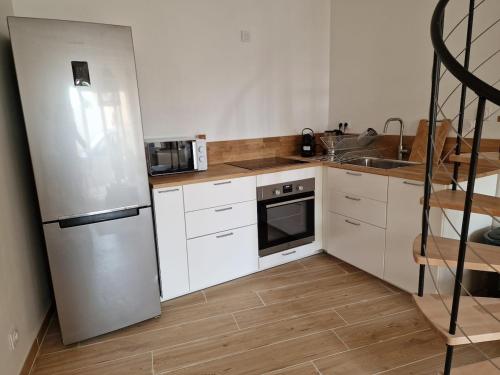 una cocina con frigorífico y fregadero en T3 Duplex - Centre-ville, en Saint-Pourçain-sur-Sioule