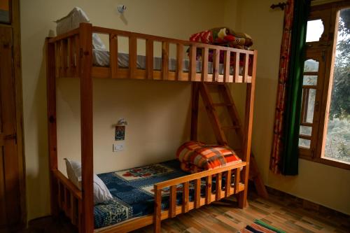 Un dormitorio con dos literas en una habitación. en MOZO Inn&Cafe Jibhi, en Banjār