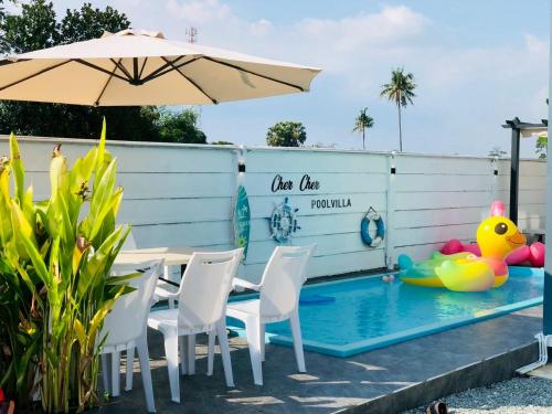 a pool with a table and chairs and an umbrella at Cher Cher Pool Villa in Ban Chang