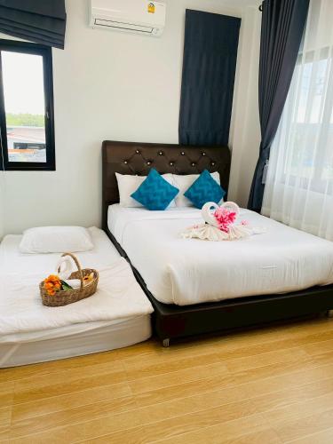 two beds in a bedroom with a basket of flowers on them at Cher Cher Pool Villa in Ban Chang