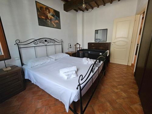 una camera da letto con un letto grande con lenzuola bianche di Bilocale indipendente a 10' da Pisa a Cascina