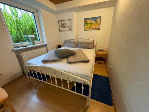 a bed in a room with a window at Gemütliche Ferienwohnung nähe Schloss Benrath & Rhein Düsseldorf Urdenbach in Düsseldorf