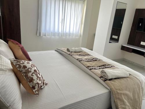 a bed with two pillows on it in a bedroom at Jeel Pearl Hotel in Udaipur