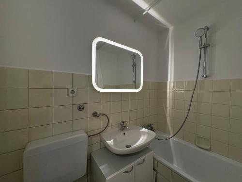 a bathroom with a sink and a toilet and a mirror at Design & Komfort für 2-4 Gäste in Munich