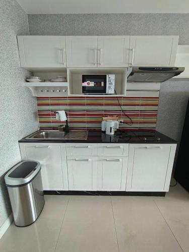 a small kitchen with white cabinets and a sink at View Talay6 by Blue Ocean Suite in Pattaya Central