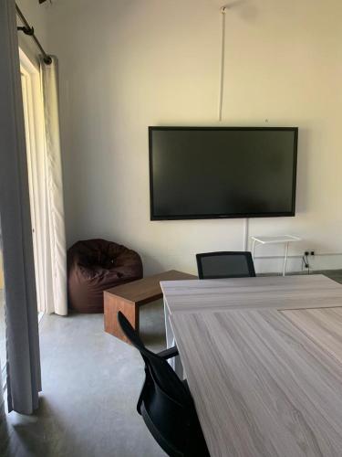 a living room with a flat screen tv on the wall at The Hostel in Mirissa