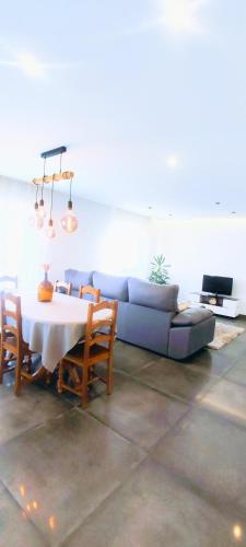a living room with a table and a blue couch at Casa com jardim privado e estacionamento no interior in Amares