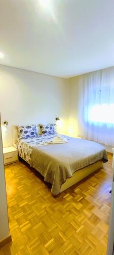 a bedroom with a large bed with a wooden floor at Casa com jardim privado e estacionamento no interior in Amares