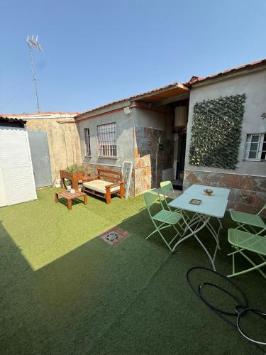 a patio with a table and chairs on a lawn at CASA KIARA in San Martín de la Vega