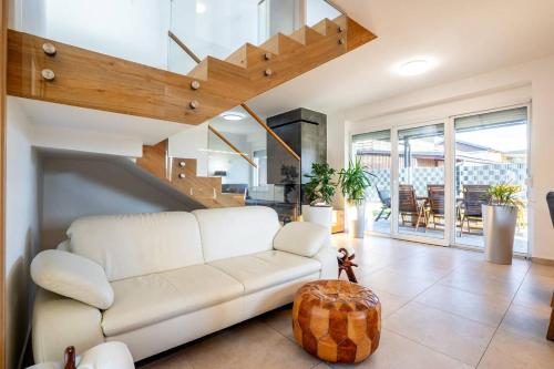 a living room with a white couch and a staircase at Villa Aqua in Moravske Toplice