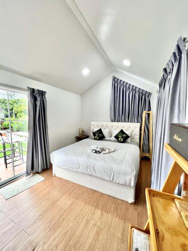 a bedroom with a white bed and a window at Baan Pranai In Pai in Pai
