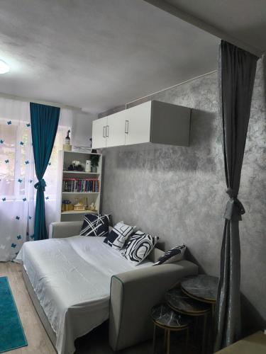 a bedroom with a white bed and a couch at Home MARIA in Orşova