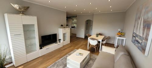 un soggiorno con un divano, una TV e un tavolo di Wohnen auf Zeit in der Maritim Residenz a Kiel