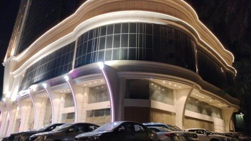 a large building with cars parked in front of it at فندق شعاع النزهة in Az Zāhir