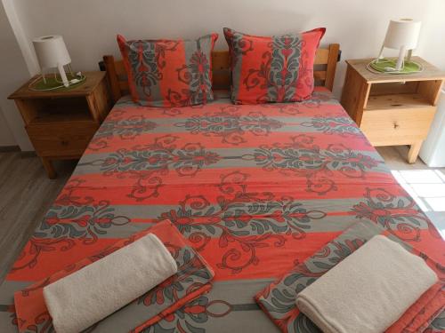 a bedroom with a bed with red sheets and pillows at Wendy House - Central Sofia - 3BRDR - Private Courtyard - 5 min to Vitosha blvd in Sofia