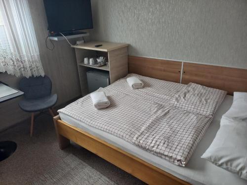 a bedroom with a bed with two towels on it at Pokoje Gościnne Jaga in Kielce