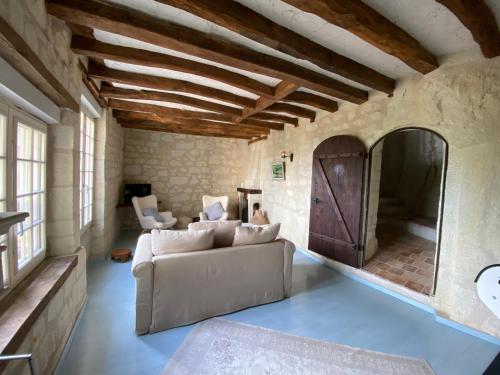 a living room with a couch and a mirror at Le chant du troglodyte in Saumur