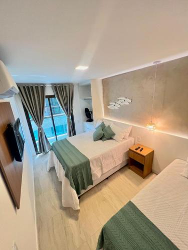 een hotelkamer met twee bedden en een televisie bij Paraiso dos Anjos in Arraial do Cabo