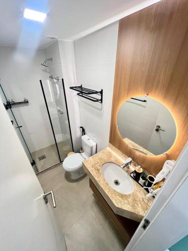 een badkamer met een wastafel en een spiegel en een toilet bij Paraiso dos Anjos in Arraial do Cabo