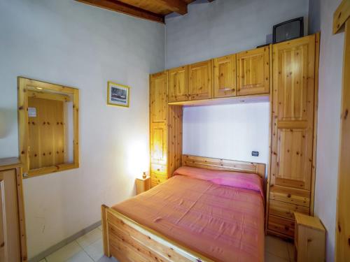 a bedroom with a wooden bed with wooden cabinets at Apartment in Antey-Saint-André near Ski Area in Antey-Saint-André