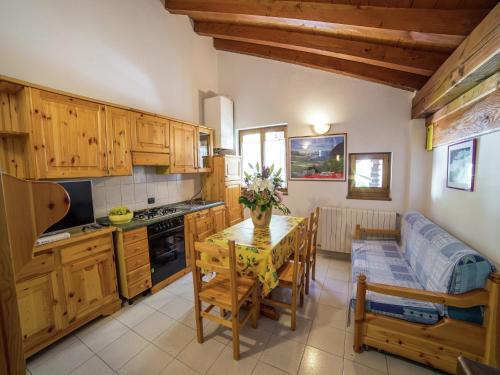 a kitchen with wooden cabinets and a table and a couch at Apartment in Antey-Saint-André near Ski Area in Antey-Saint-André