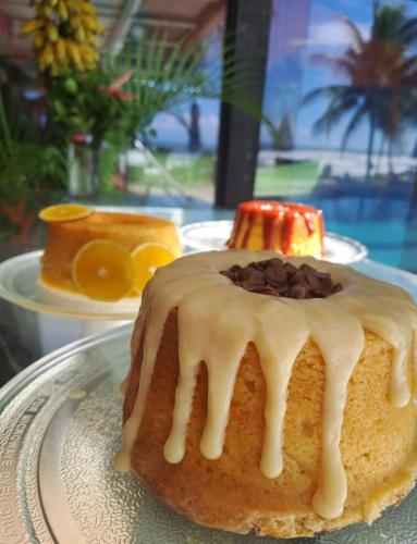 a cake with chocolate chips on a plate on a table at Eden One in Ilhéus