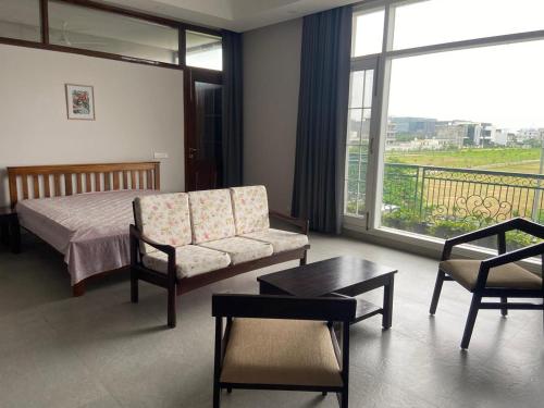 a bedroom with a bed and a couch and a table at IT City Homestay-Secure & Comfortable Stay in Mohali in Mohali