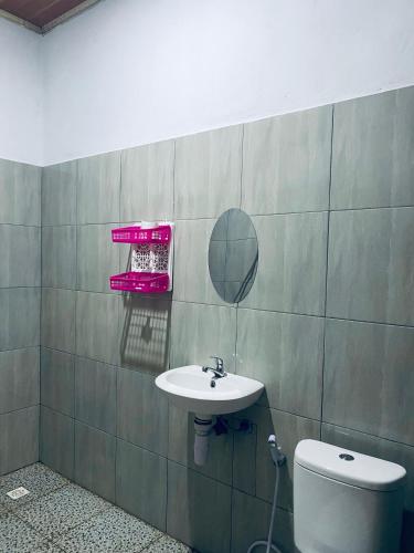 a bathroom with a sink and a mirror and a toilet at Raya Homestay in Kuta Lombok
