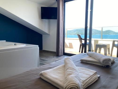 a bathroom with towels on a bed with a view at Olimpia Hotel in Fethiye