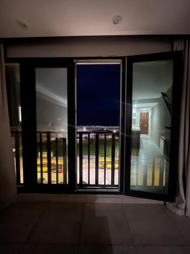 an open glass door with a view of a balcony at Depto vista directa al mar con Piscina climatizada in Necochea