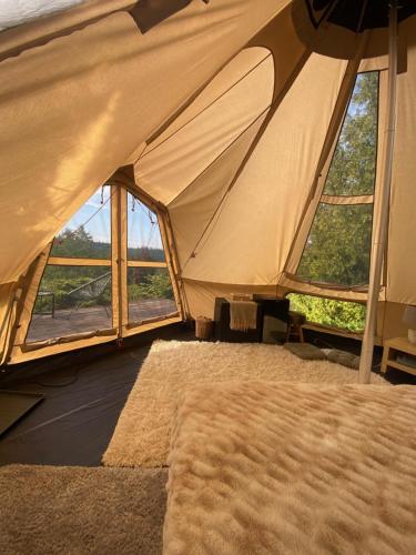 a tent with a rug in a room with windows at Hvězdný glamping in Manětín