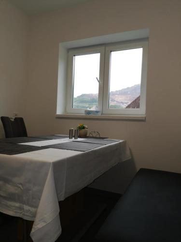 a bed in a room with two windows at Eisenerzer Apartments - Radmeisterhaus in Eisenerz