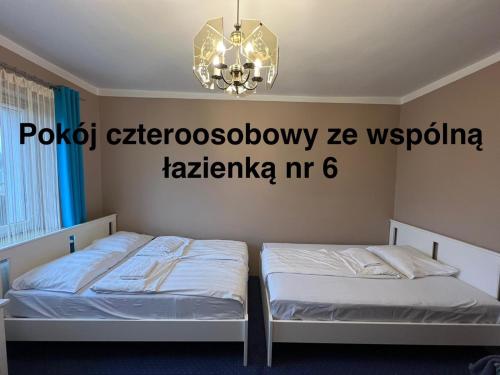 a bedroom with two beds and a chandelier at Noclegi AirportPark in Pyrzowice