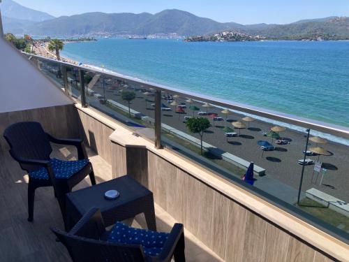 a balcony with chairs and a view of a beach at Olimpia Hotel in Fethiye