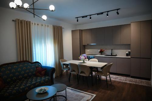 a living room with a couch and a table with chairs at Olive Tree in Tirana