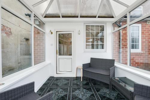 eine abgeschirmte Veranda mit 2 Stühlen und einer Tür in der Unterkunft Sand Dancer Haven - North East Escapes in South Shields