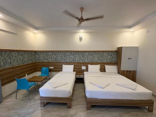 a hospital room with two beds and two chairs at Vainavi Residency in Tirupati