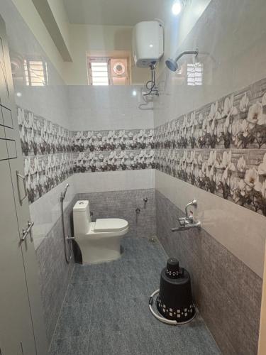 a bathroom with a toilet and a sink at Vainavi Residency in Tirupati